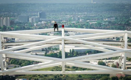 Un escalador trepa hasta la zona más alta del arco del estadio de Wembley